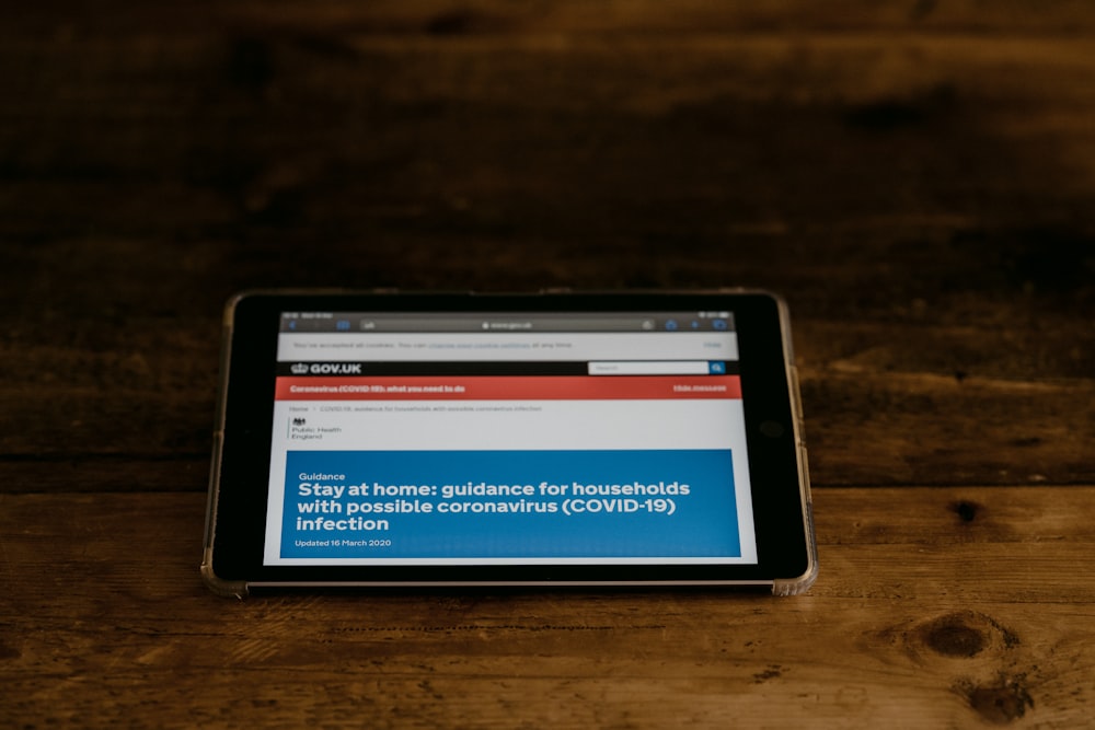 black tablet computer on brown wooden table