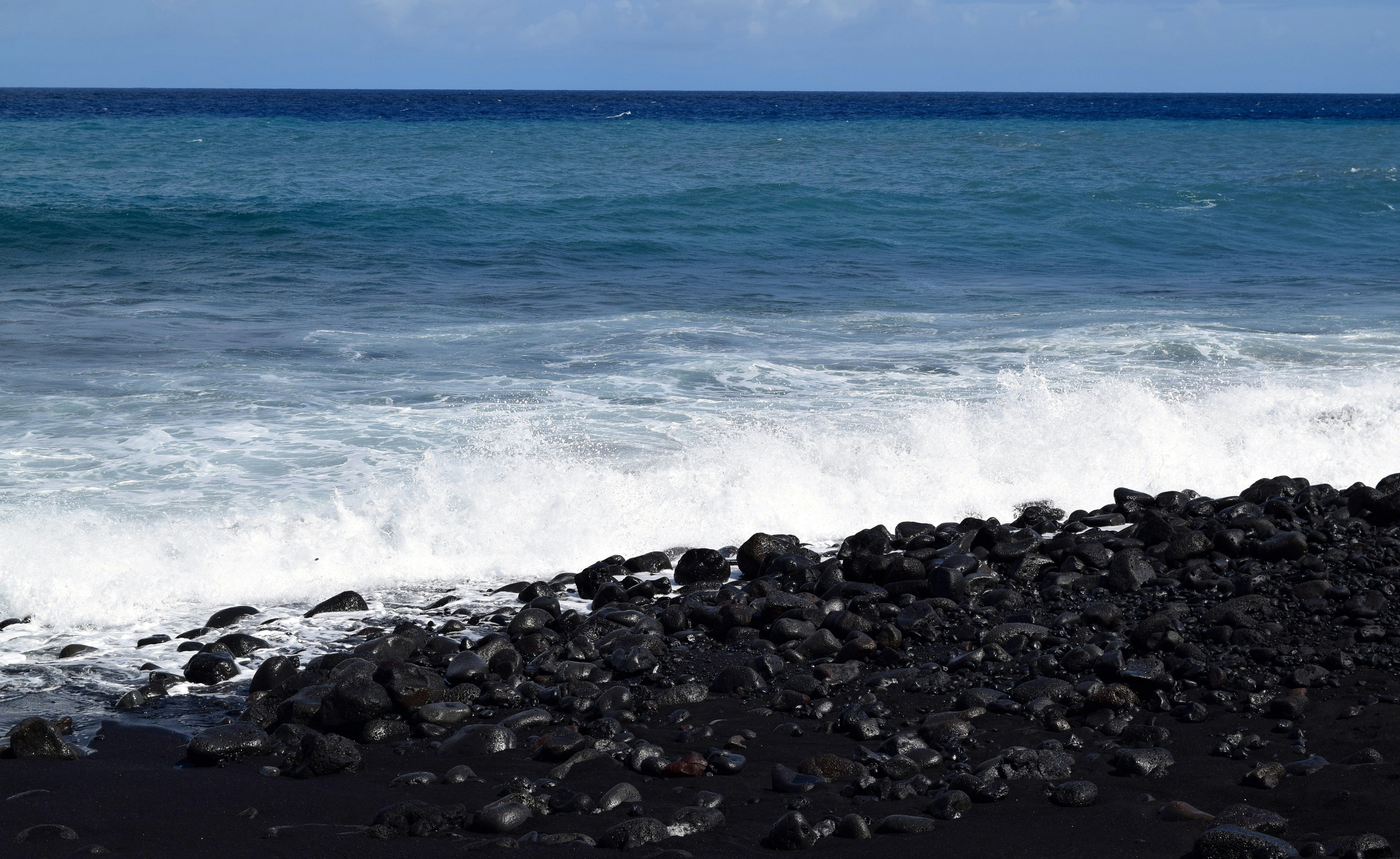 sea waves crashing on rocky shore during daytime