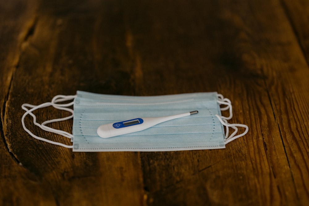 cepillo de dientes blanco y azul sobre textil blanco