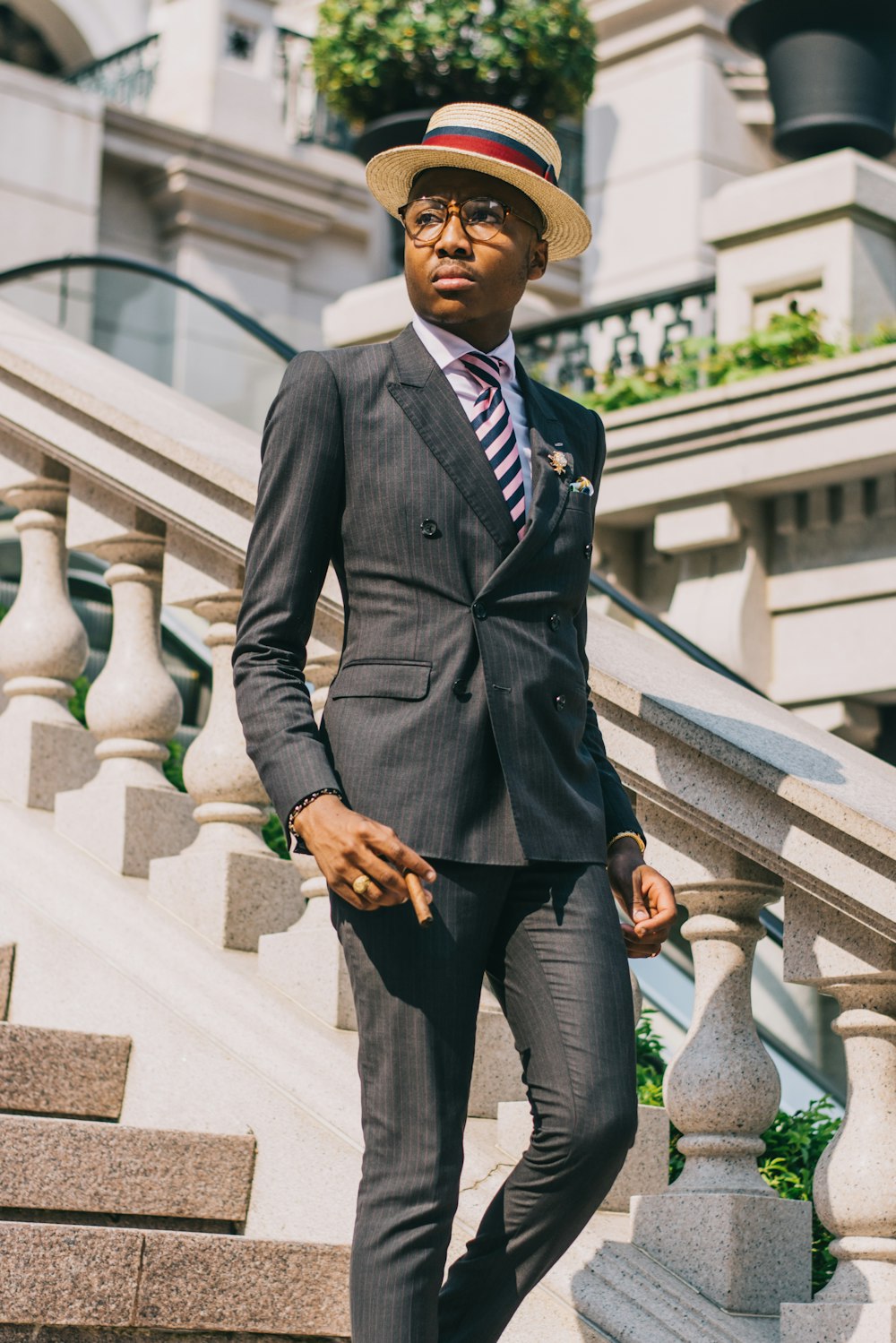 man in black suit jacket and black dress pants standing on gray concrete stairs during daytime