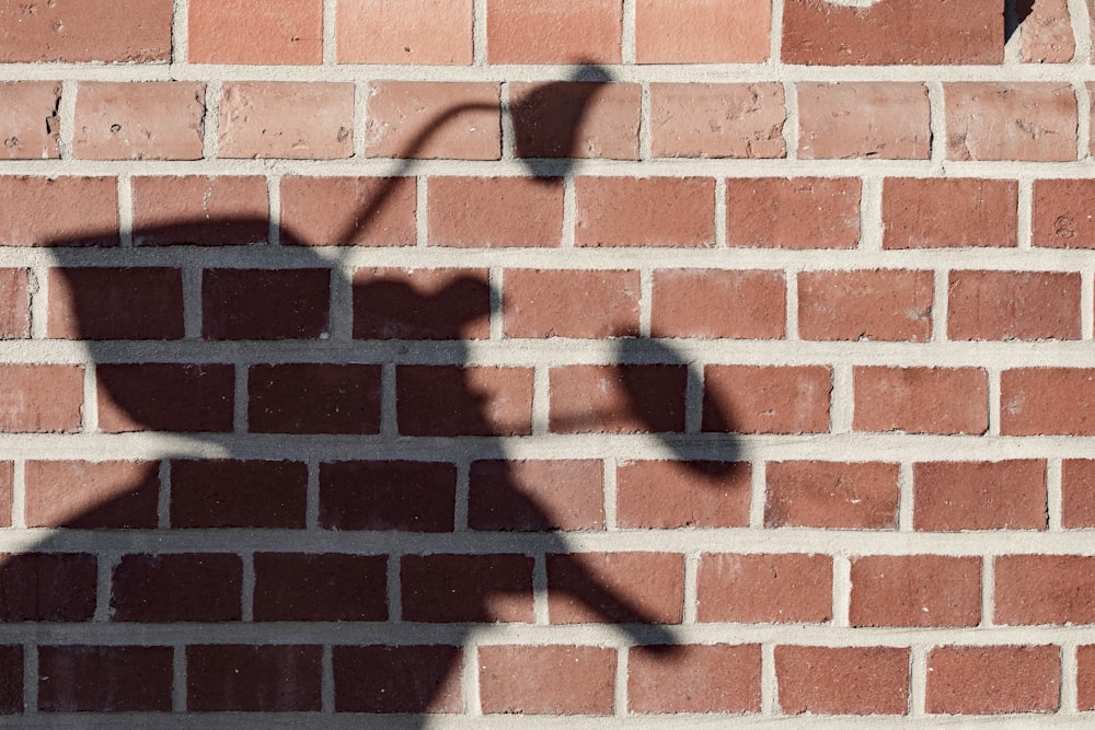 muro di mattoni marroni con gancio a parete in metallo nero