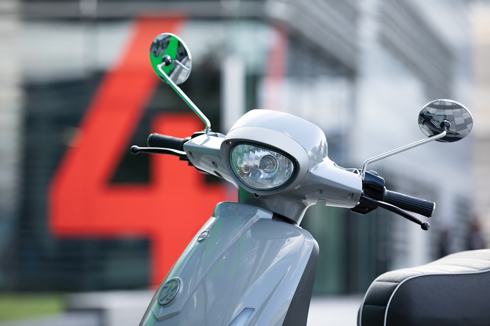 gray motor scooter with green and yellow bicycle helmet