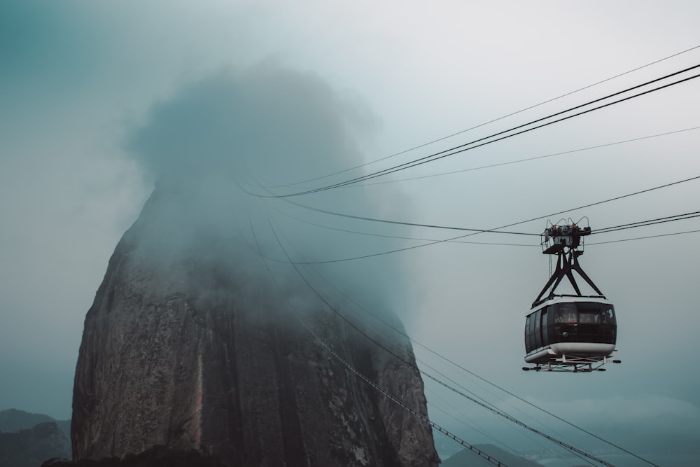 Teleférico blanco y negro bajo nubes blancas