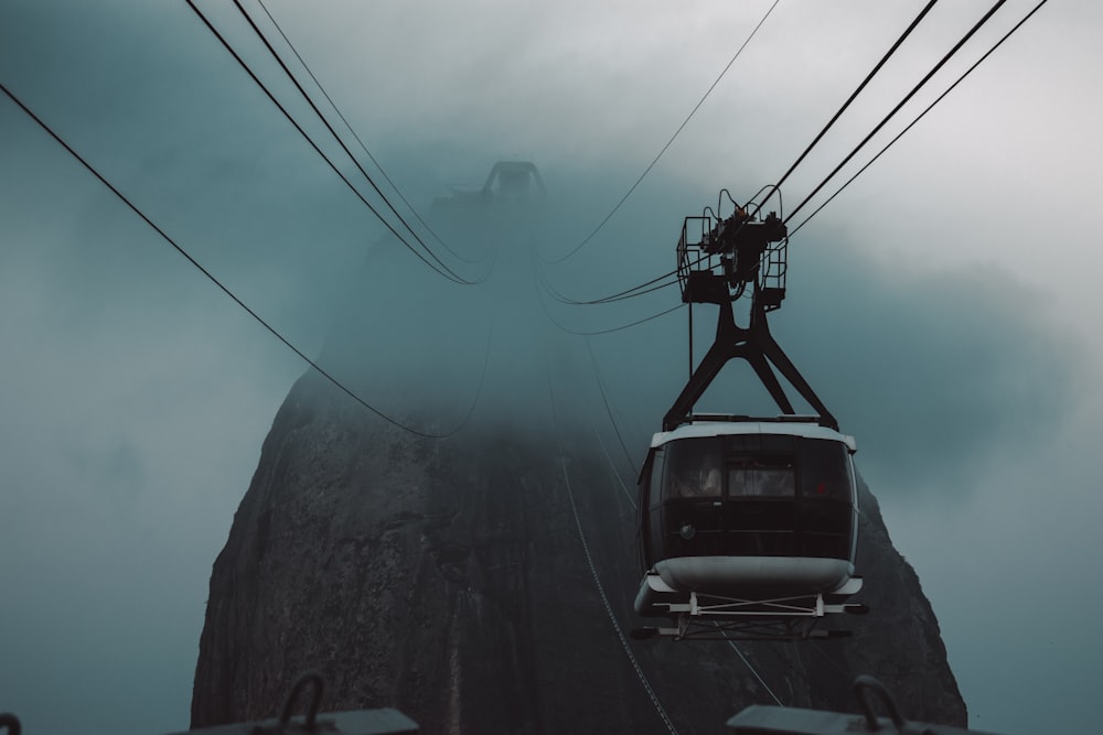 blue car on black metal cable wire under white clouds