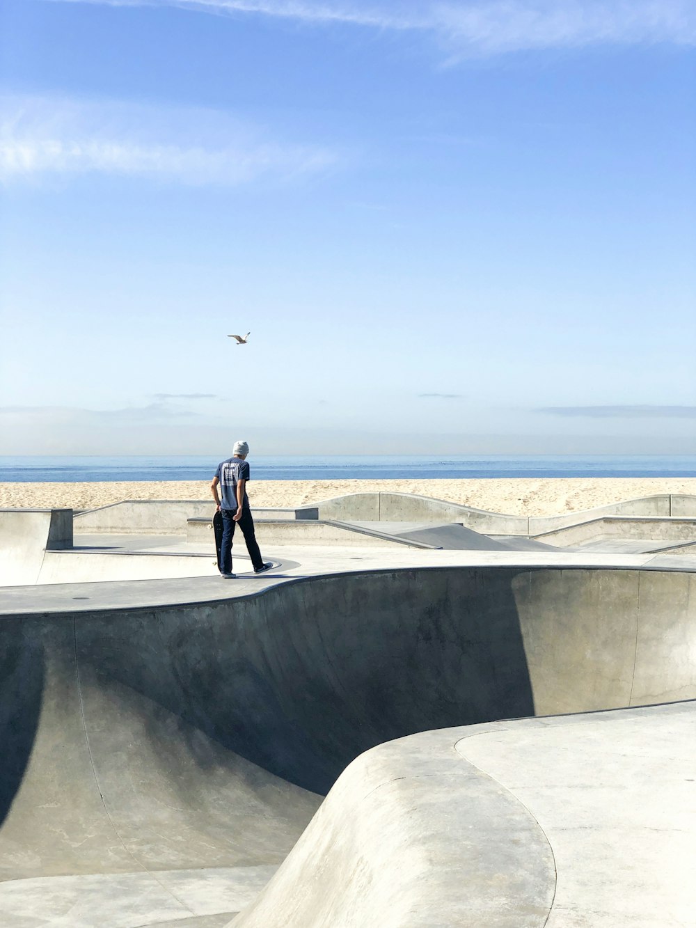 man in black jacket and pants standing on gray concrete wall during daytime