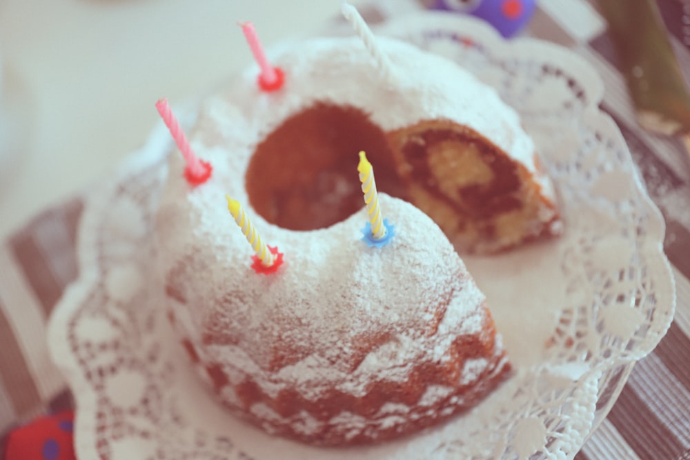 white and brown cake with white and yellow straw on white and pink floral ceramic plate