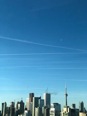 A sleek aerial view of a modern high-rise development in downtown Toronto under clear blue skies.