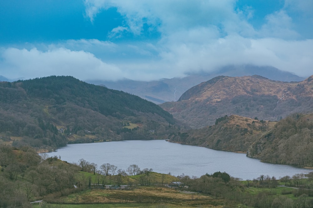 green mountains near body of water under blue sky during daytime