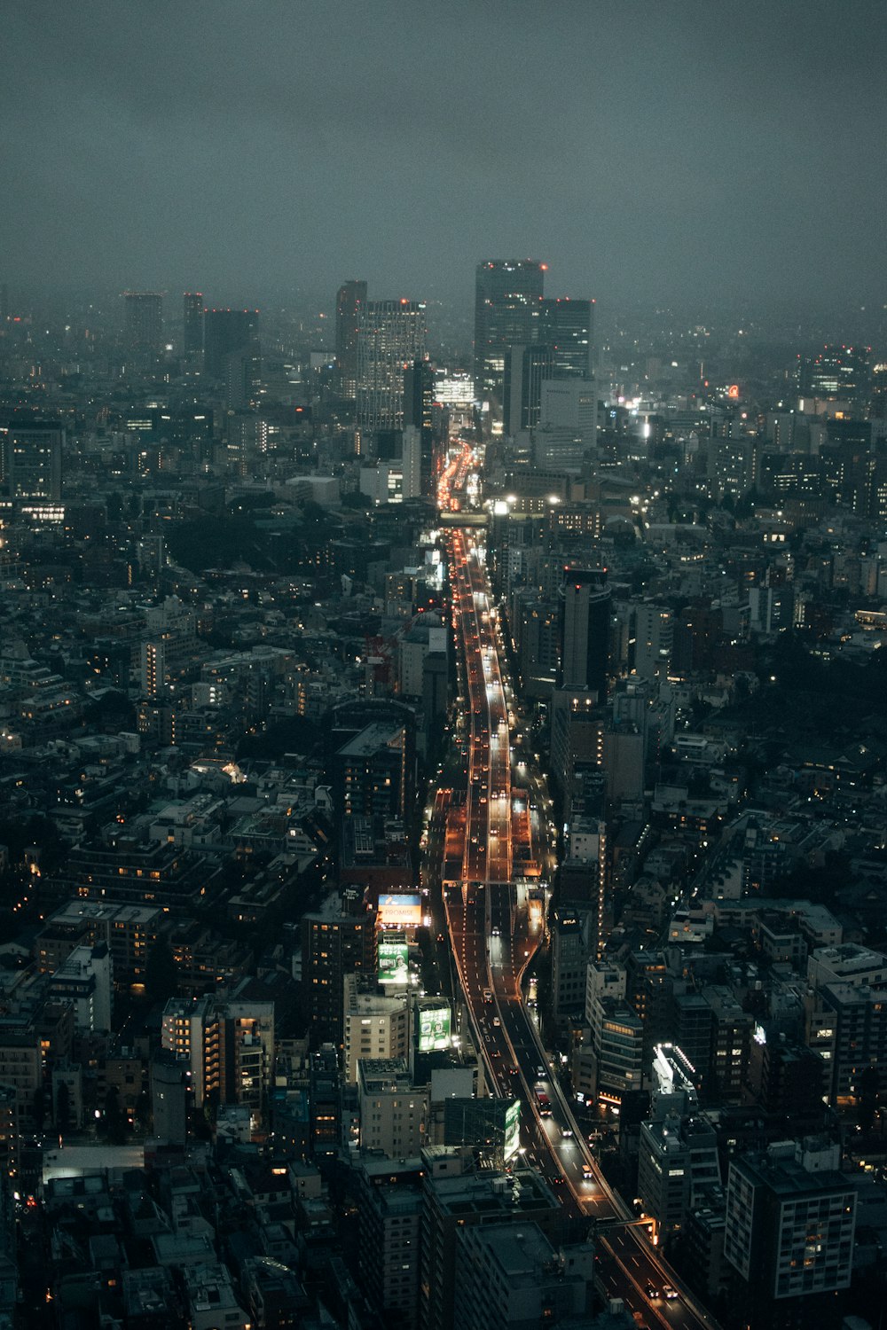 uma vista de uma cidade à noite do topo de um edifício alto