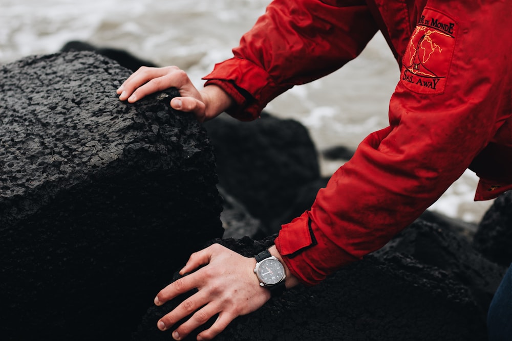 person in red jacket wearing silver and black watch