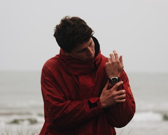 man in red hoodie holding black dslr camera