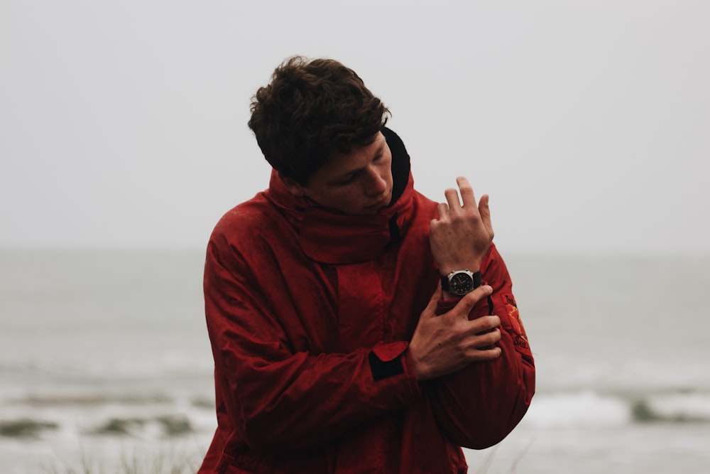 man in red hoodie holding black dslr camera