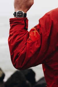 person in red jacket wearing black and silver watch