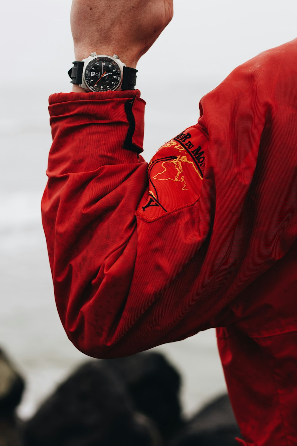 person in red jacket wearing black and silver watch