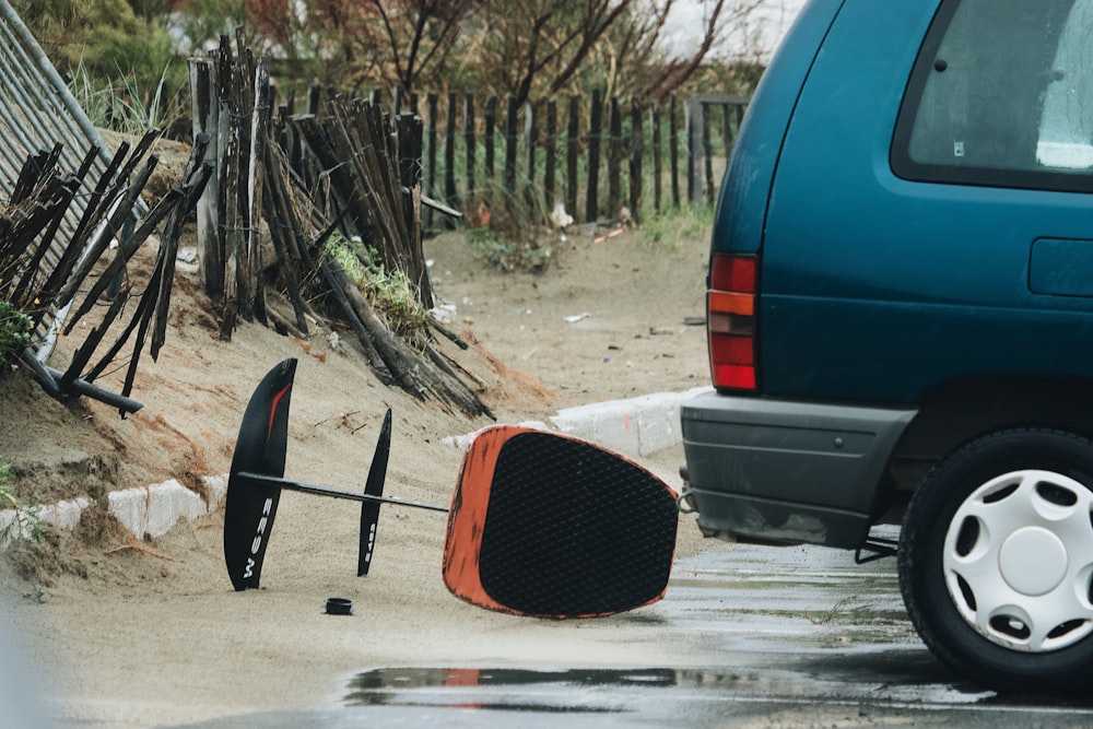 skateboard nero e arancione su auto grigia