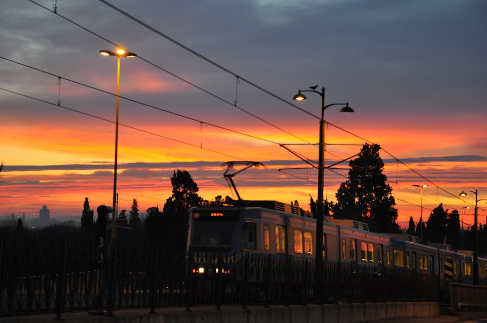 white and red train on rail during sunset