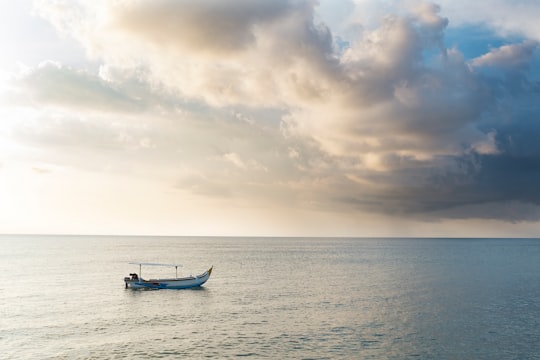 silhouette of 2 people riding on boat on sea during sunset in Kuta Indonesia