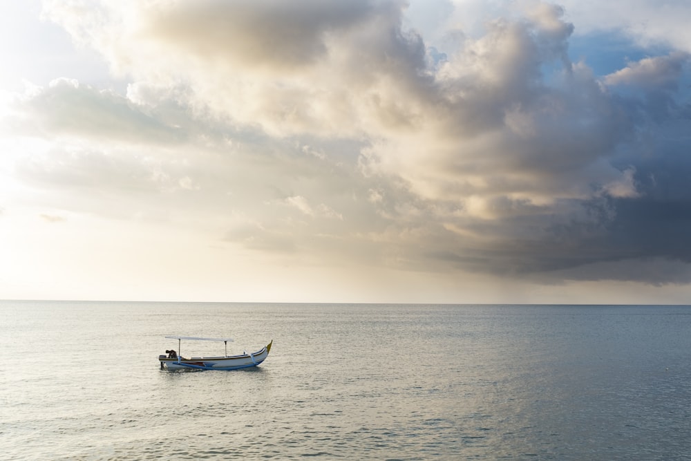 silhouette of 2 people riding on boat on sea during sunset