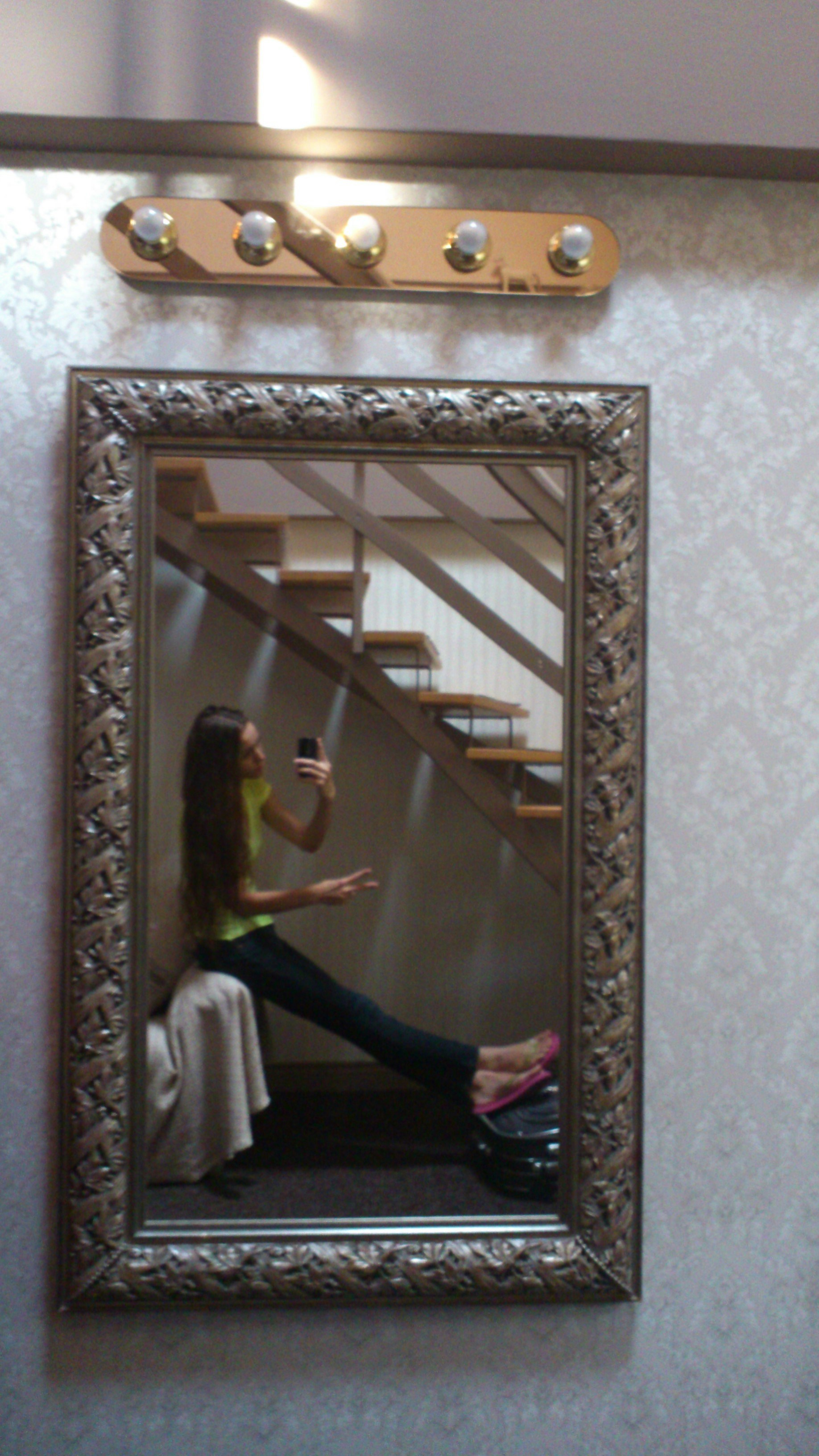 a woman taking a picture of herself in a mirror