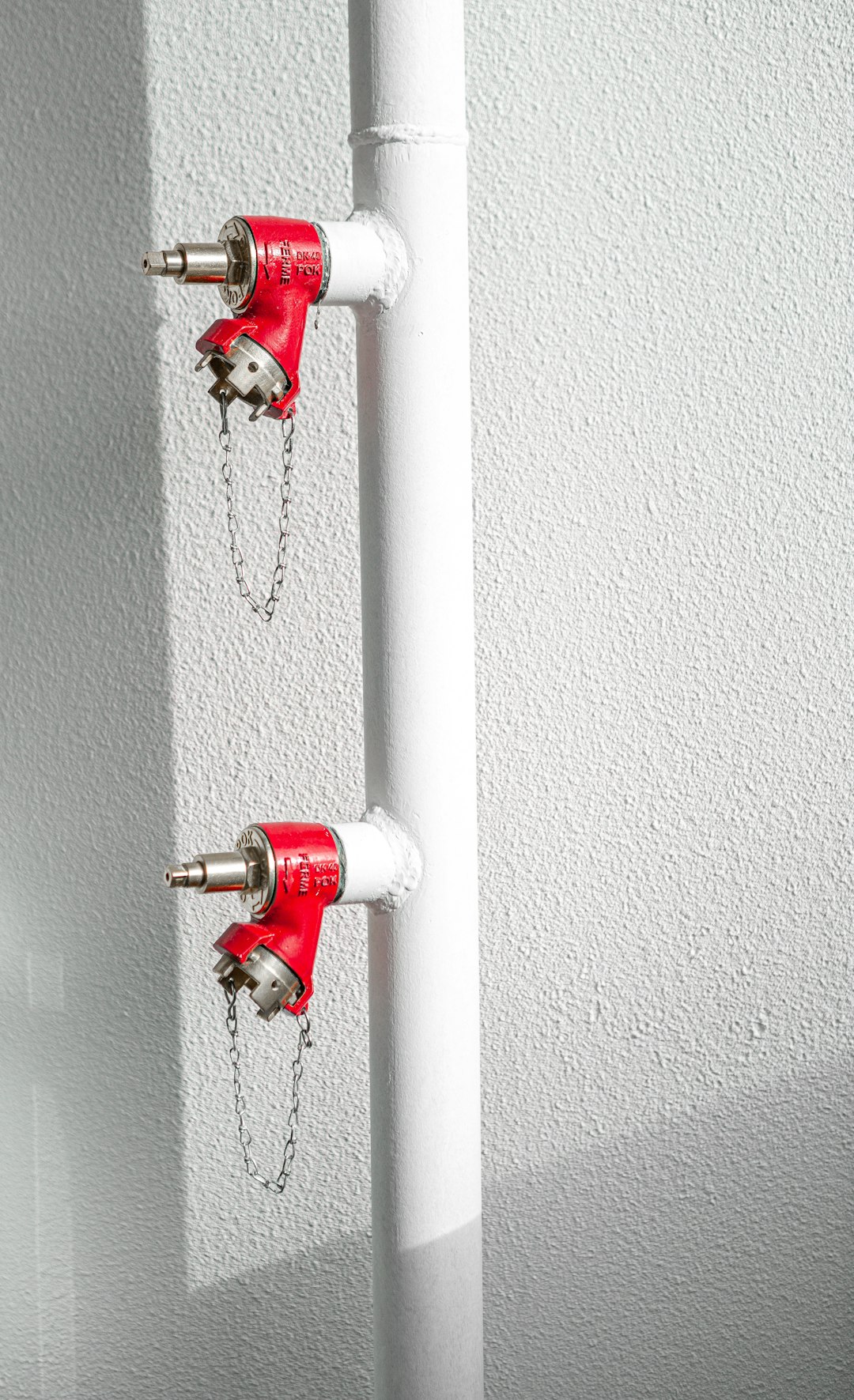 red fire extinguisher on white wall