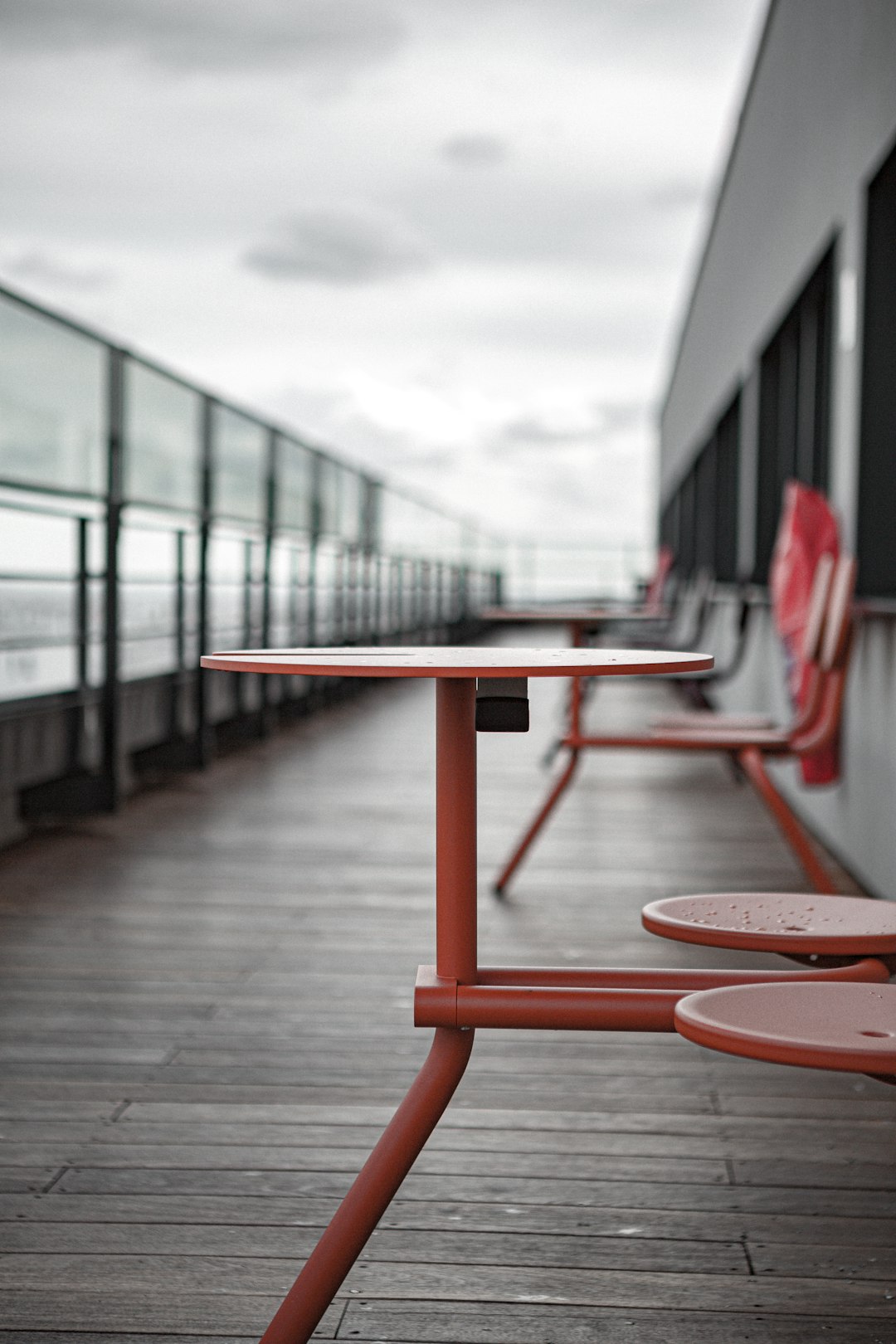 red metal table and chairs on wooden deck
