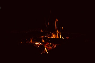 A cozy campfire glowing softly against a twilight canyon backdrop.
