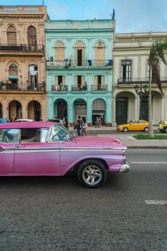 pink car parked beside building during daytime in Central Park Cuba