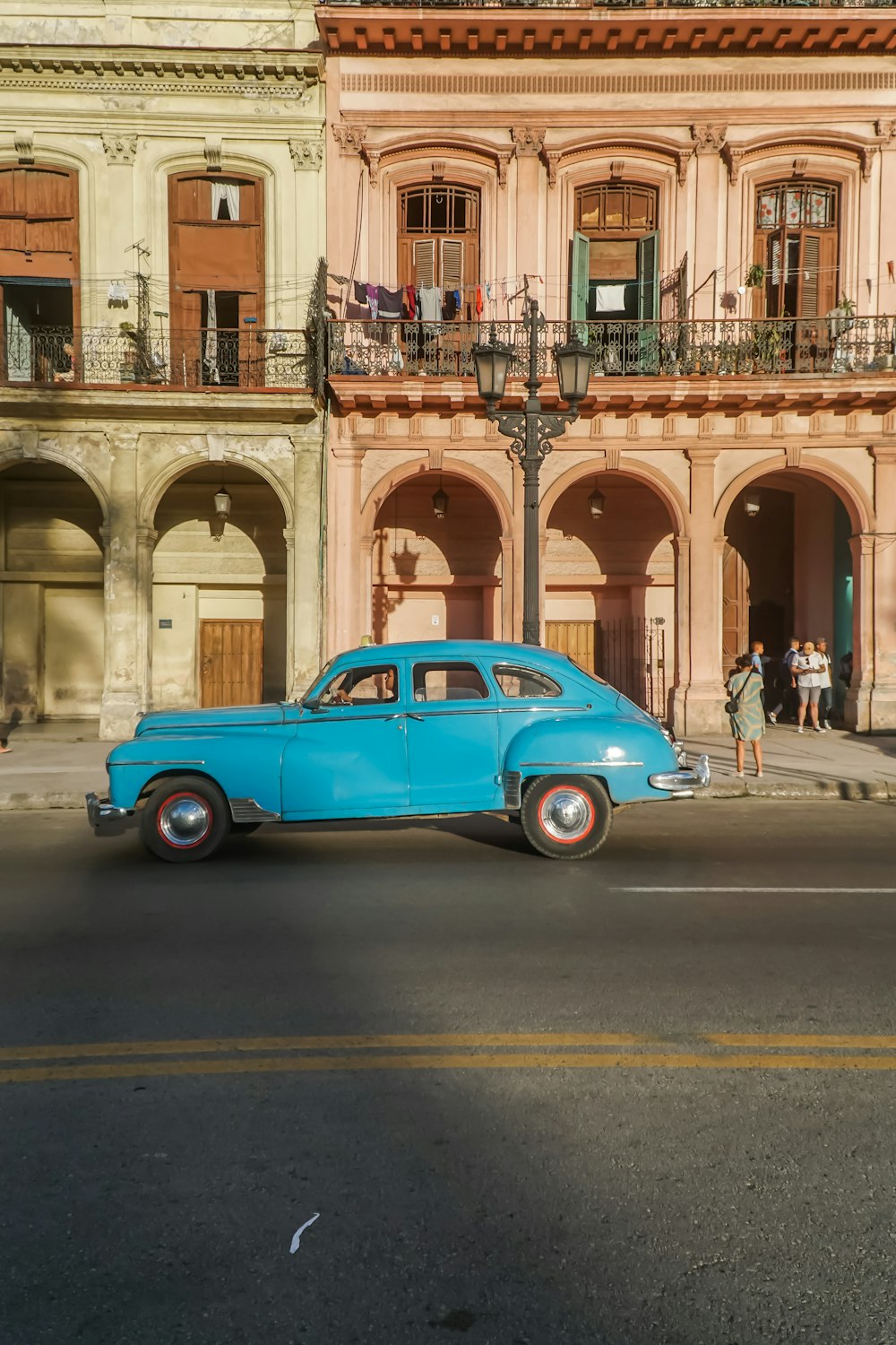 blue car on road near building during daytime