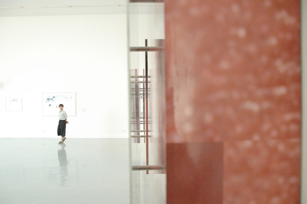 man in white shirt walking on hallway