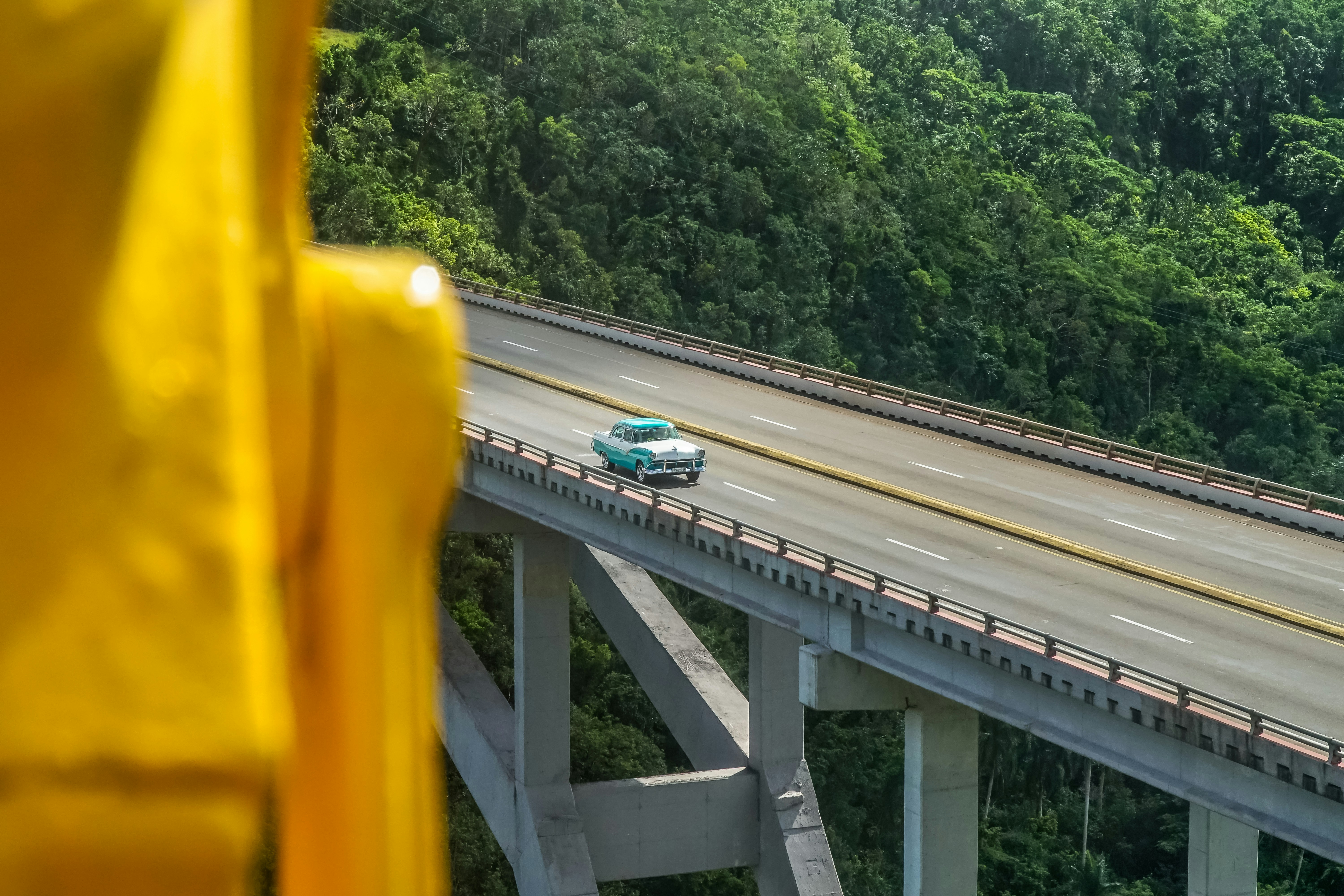 Autobús azul y blanco en puente de hormigón gris durante el día