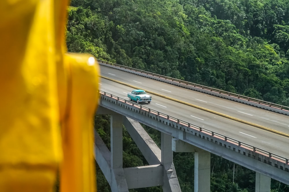 blue and white bus on gray concrete bridge during daytime