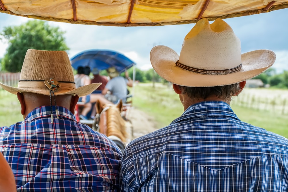 man in blue and white plaid dress shirt wearing brown hat