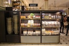 A shopper selecting dry goods from a large warehouse-style shelf filled with bulk items.