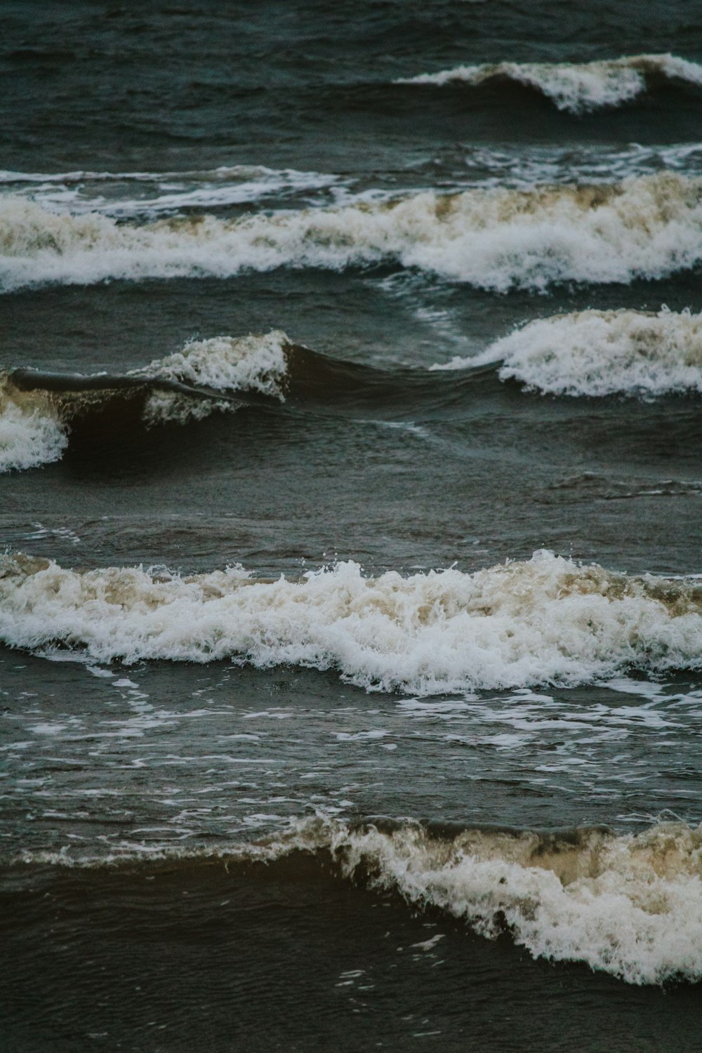 ocean waves crashing on shore during daytime