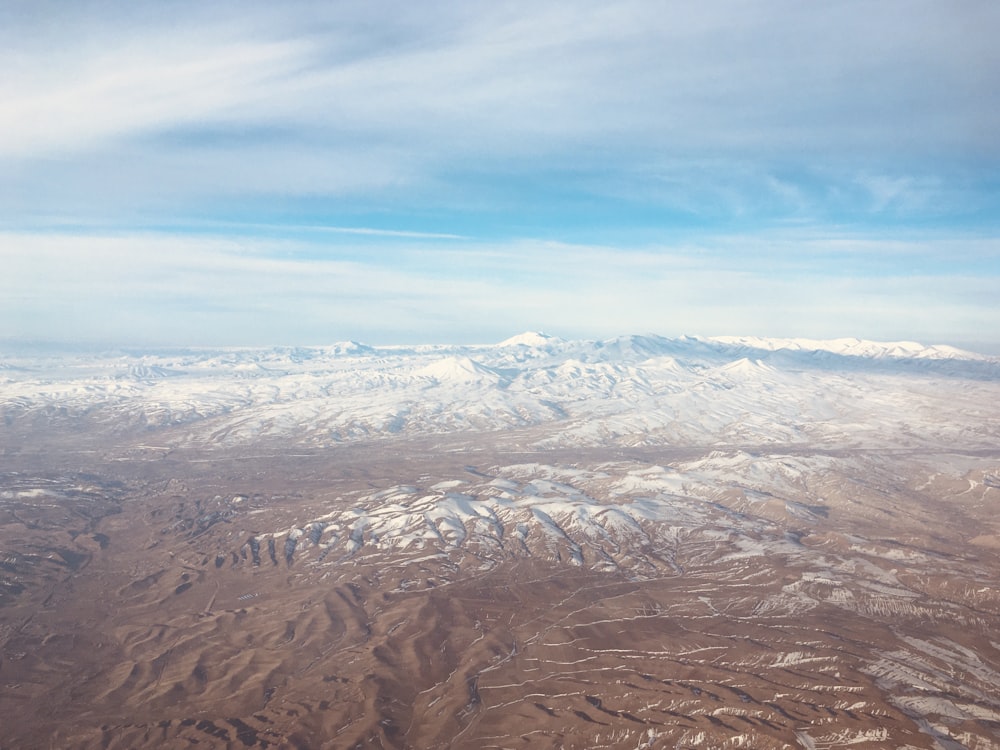 Vista aérea de las montañas marrones bajo el cielo azul durante el día