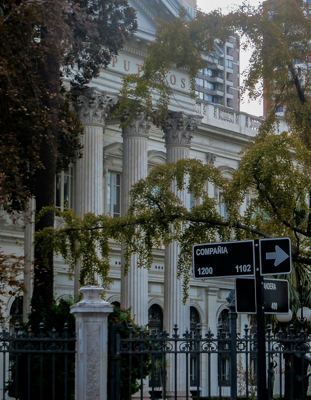 edificio in cemento bianco vicino agli alberi verdi durante il giorno