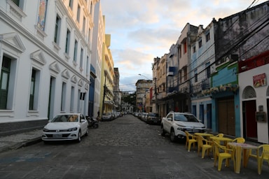 cars parked on side of the road in between buildings during daytime
