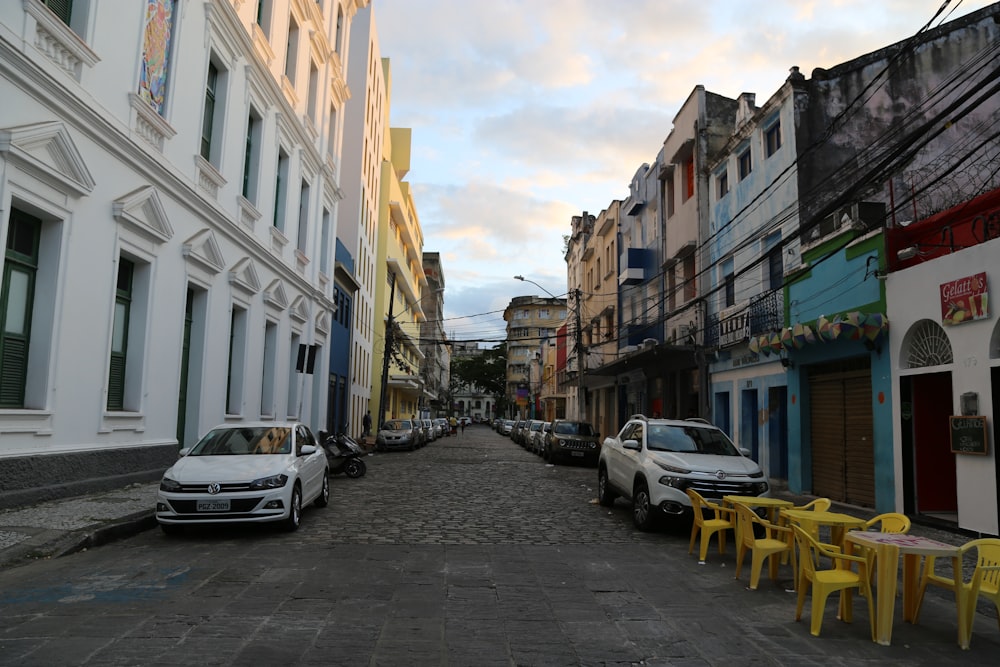 cars parked on side of the road in between buildings during daytime