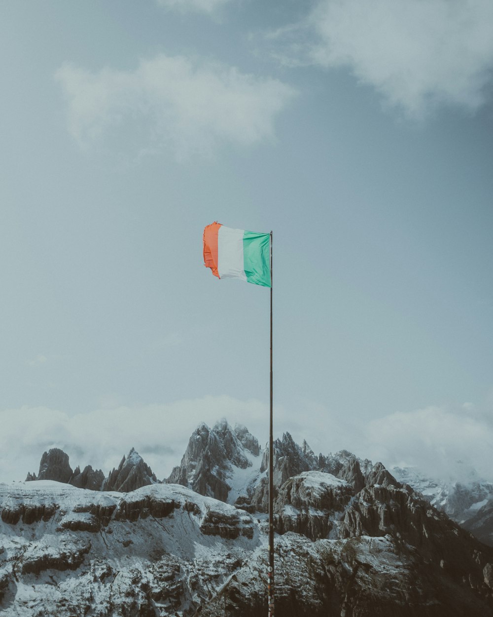 bandeira verde na montanha coberta de neve durante o dia