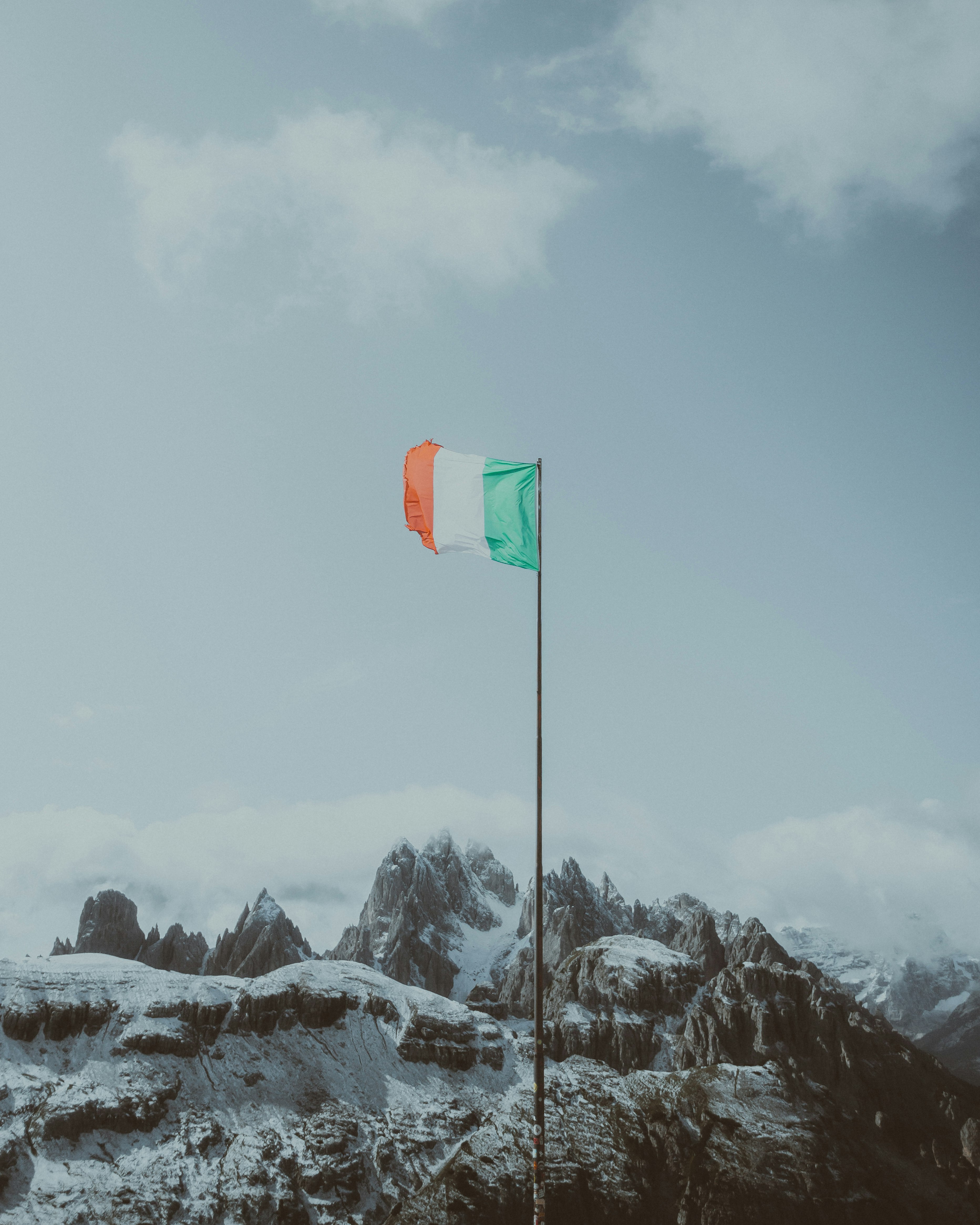 green flag on snow covered mountain during daytime