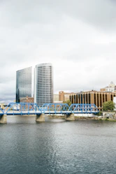 blue bridge over river near city buildings during daytime