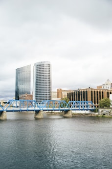 blue bridge over river near city buildings during daytime