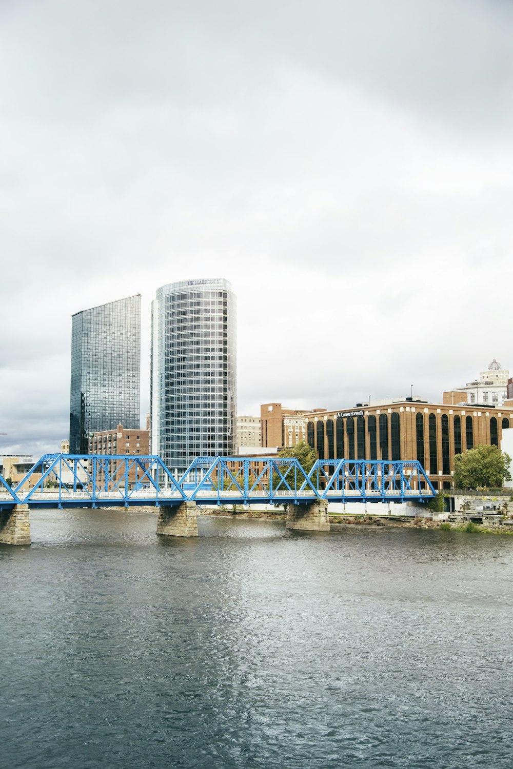 Pont bleu au-dessus de la rivière près des bâtiments de la ville pendant la journée