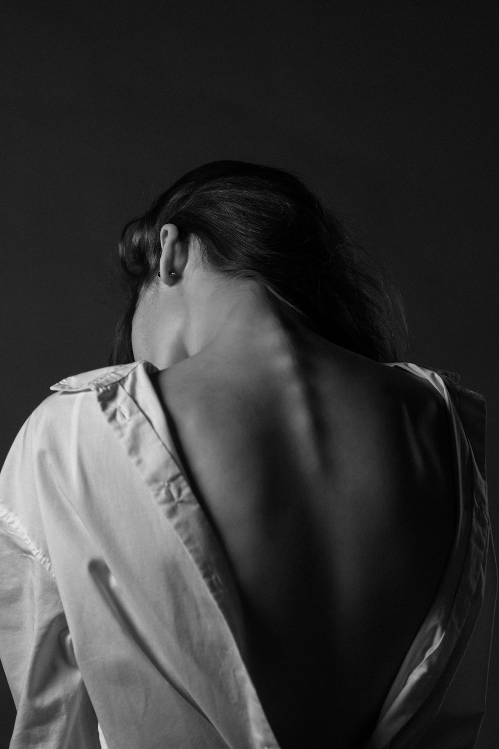 Photo en niveaux de gris d’une femme en chemise blanche boutonnée