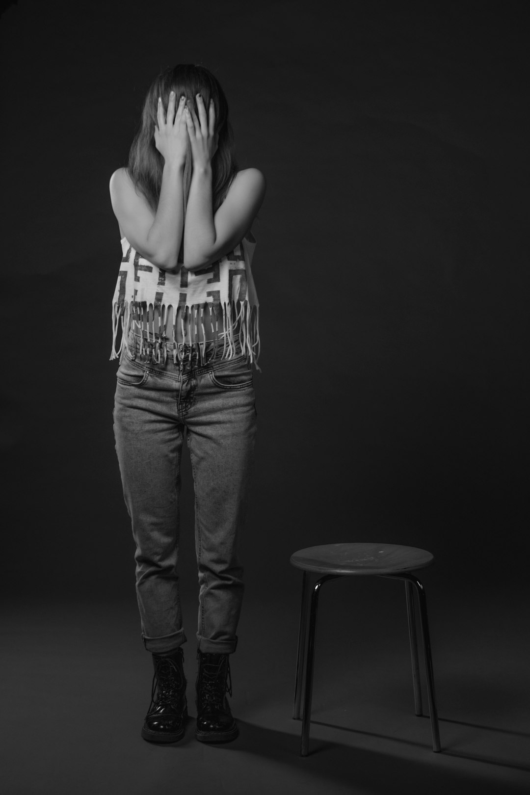 grayscale photo of woman in tank top and denim jeans