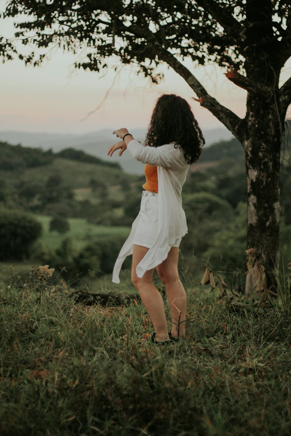 woman in white dress standing on green grass field during daytime