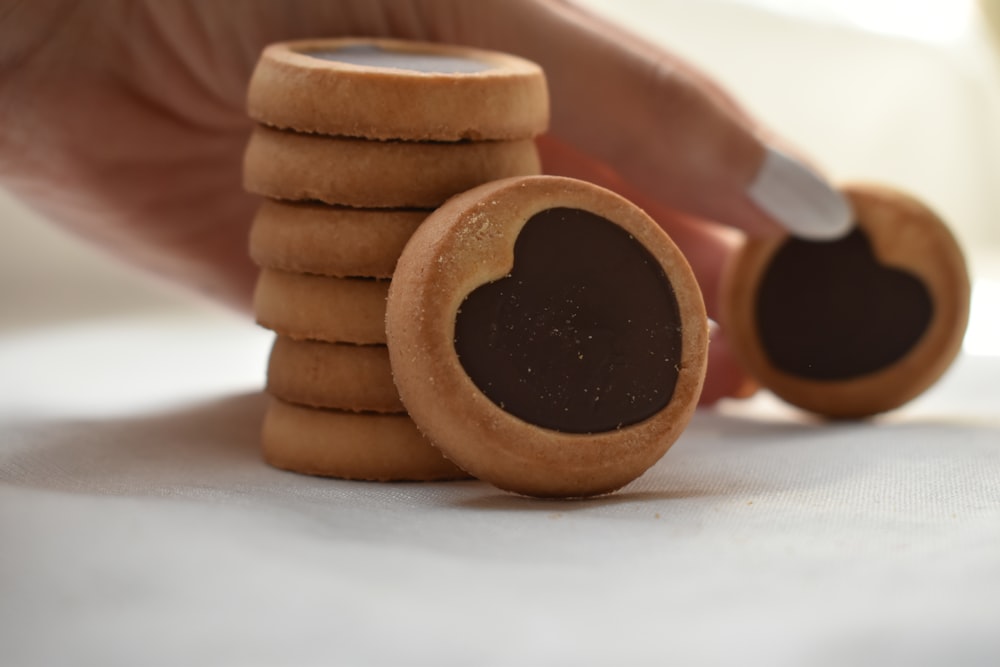a stack of cookies with a person holding a knife