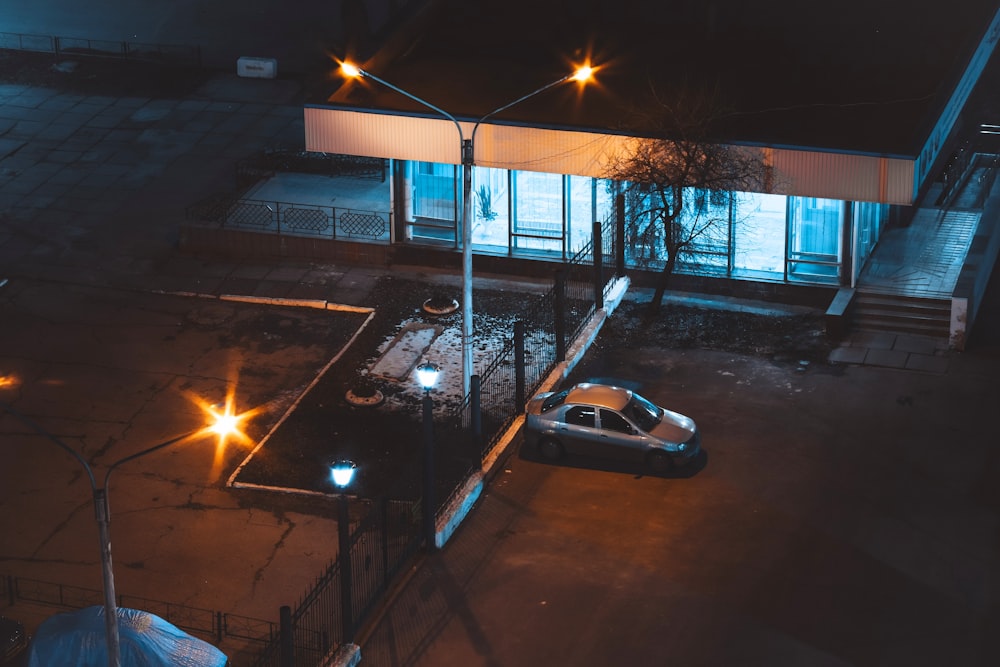 berlina bianca parcheggiata vicino all'edificio durante la notte