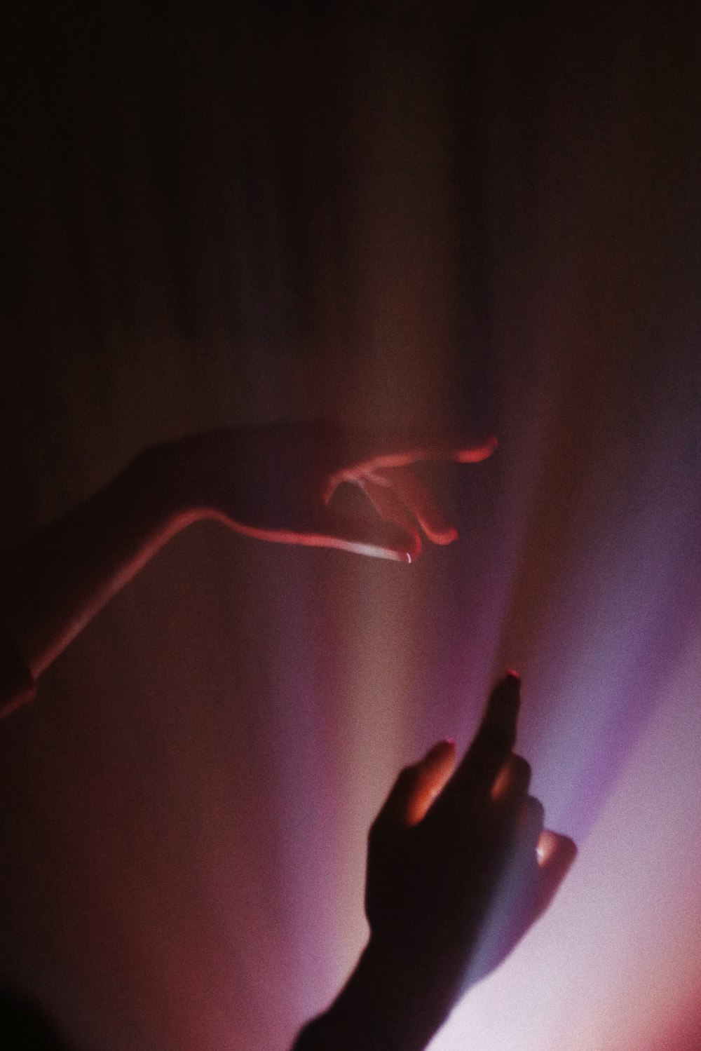 person holding red light in dark room