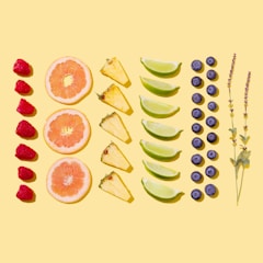 A colorful display of fresh fruits and herbal teas arranged on a rustic wooden table.
